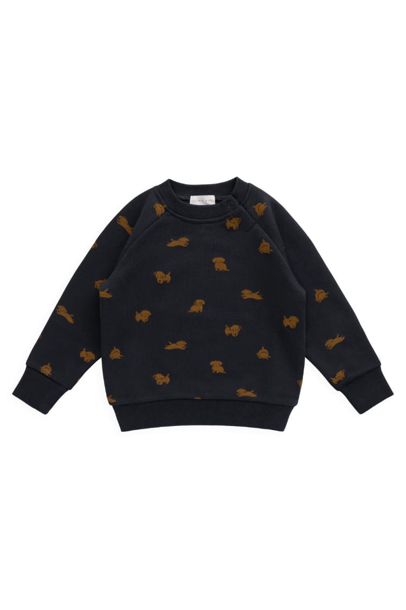 A navy long-sleeve crewneck sweatshirt with an all-over pattern of small brown dog silhouettes, laid flat against a white background with white brand tag visible "Jamie Kay". Organic and available at Grace & Haven.