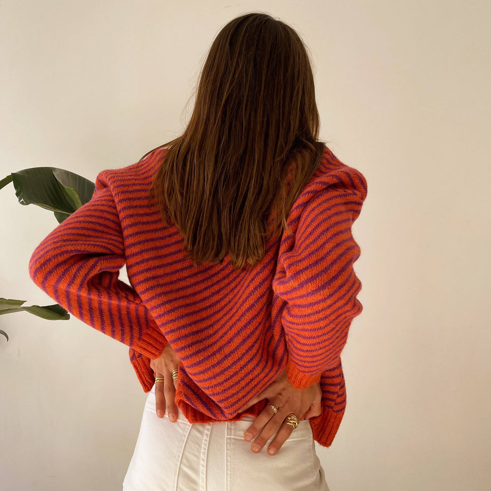 
                      
                        Featuring eye-catching stripes in shades of orange and purple, this sweater is designed to make a statement. 
                      
                    