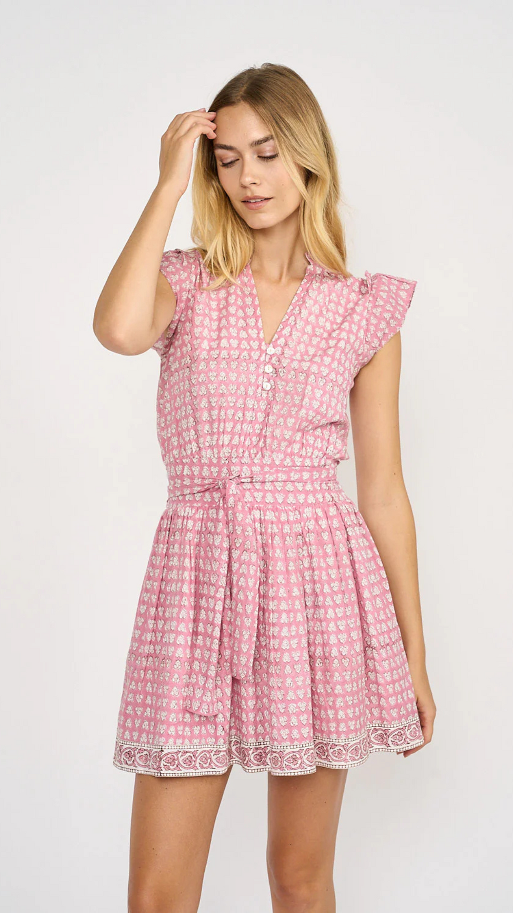 The Liz Dress embodies effortless style with its smocked back for a comfortable fit, practical pockets, a charming tie at the waist, and shell button details. 