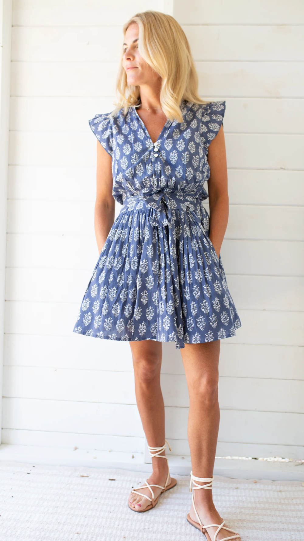 Playful Liz dress with a smocked back, functional pockets, tie feature, and shell button embellishments, perfect for sunny days