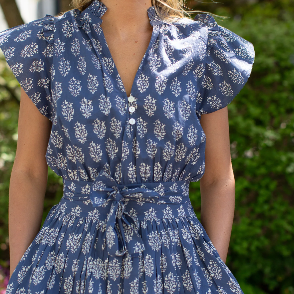 Liz dress featuring a smocked back, pockets, tie, and shell button details, perfect for any summer occasion