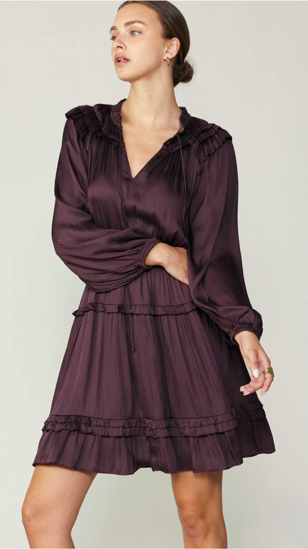 Model wearing Midnight Plum tiered dress with long sleeves and V-neckline