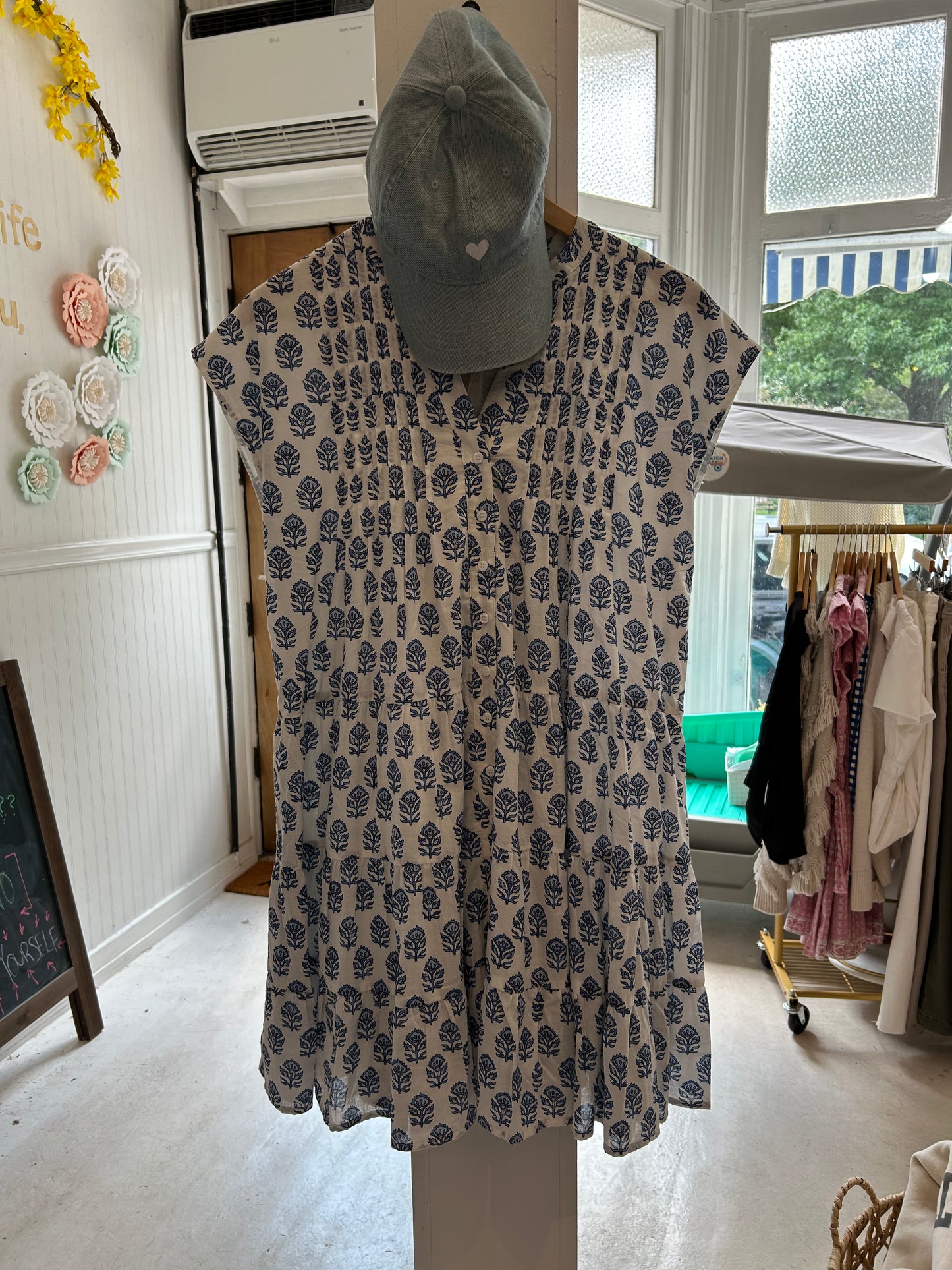 Mackenzie Dress by Marea in Atlantic Bordeaux hanging with our "Love Her But Leave Her Wild" denim heart hat in store, featuring a relaxed fit, functional buttons, and fully lined lightweight fabric, perfect for spring outings and casual weekends.