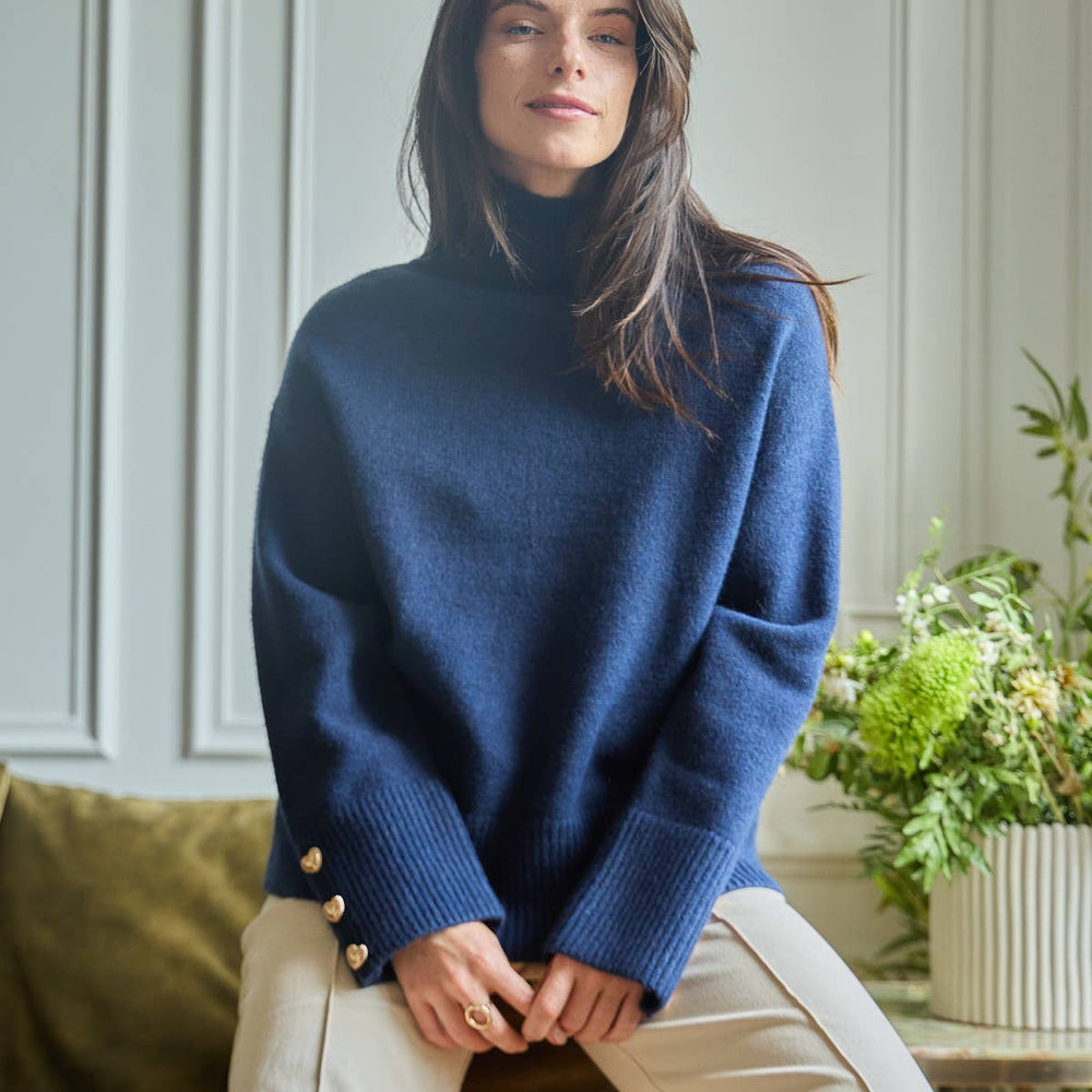 Magnolia Sweater with ribbed turtleneck and gold heart-shaped buttons on the cuffs.