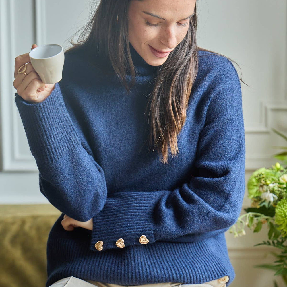 Women’s cozy Magnolia Sweater made from wool blend fabric, featuring gold heart buttons on the cuffs.