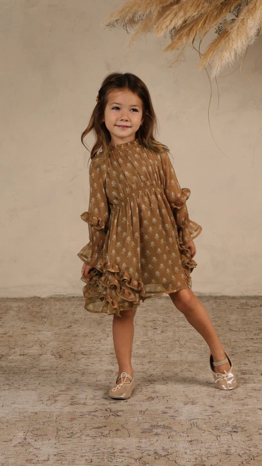 Toddler wearing the Mirabelle Dress in Daisy print, showcasing ruffles and cinched waist