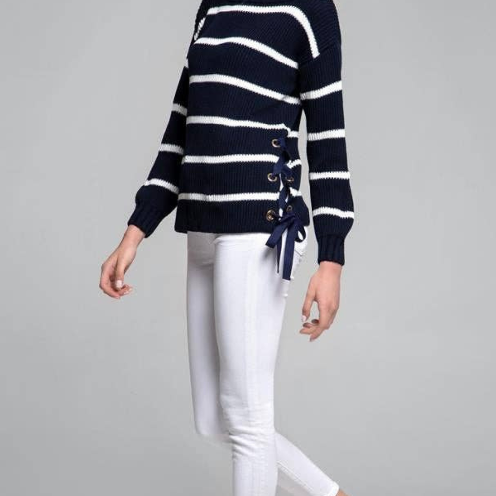 Model wearing Monaco Sweater in midnight blue and white with side slit and gold metal eyelets