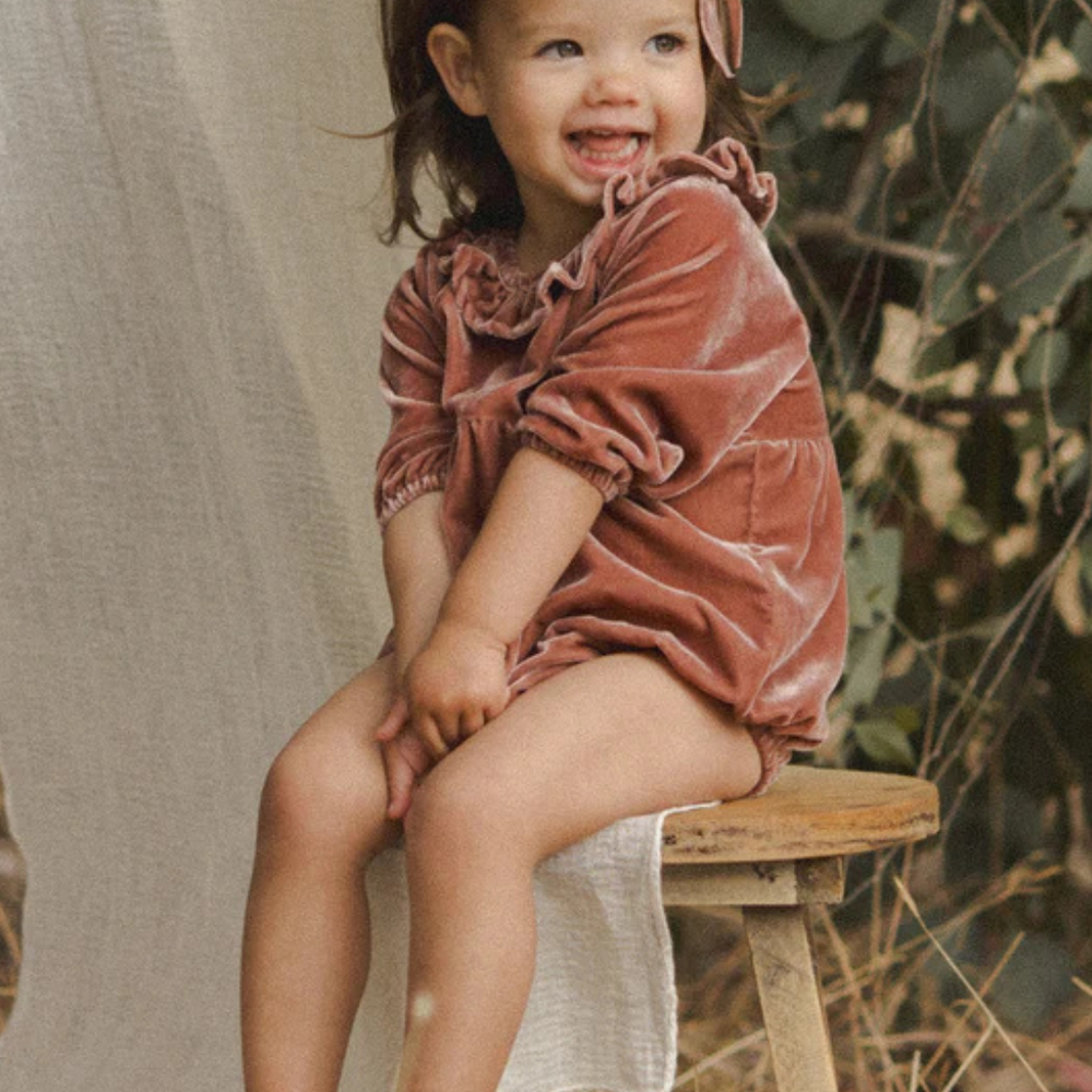 
                      
                        Close-up of the Adeline Velvet Romper’s delicate gathering and unique embroidery, showcasing its vintage charm.
                      
                    