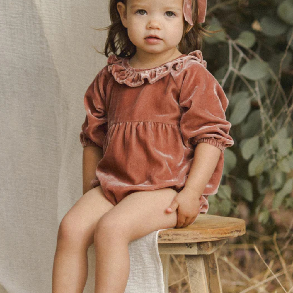 
                      
                        Front view of the Adeline Velvet Romper in Poppy with ruffled collar and embroidered detailing.
                      
                    