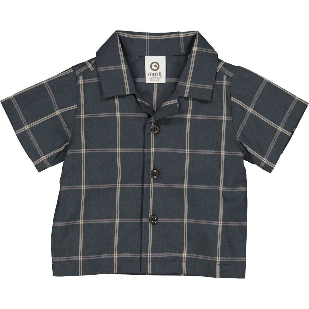 Flatlay of a baby short sleeve check shirt made from 100% organic cotton, featuring a classic collar and button-front closure, displayed on a neutral background. Ideal for layering under sweaters or vests for fall outfits.
