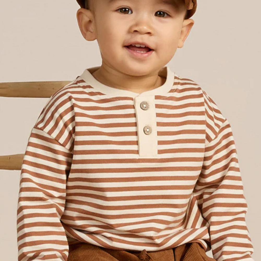 Toddler model wearing cinnamon stripe Henley Tee with matching corduroy cap by Quincy Mae, ideal for fall outings.