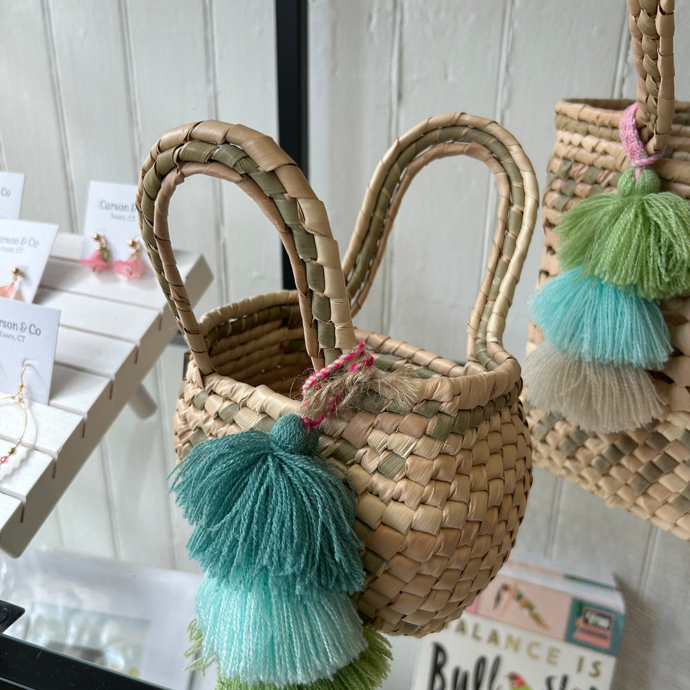 Photo of the Palm Net Yatzil Mini Tote in Sage displayed on the shelf at Grace & Haven, showcasing its handwoven palm leaf design, compact size, and artisanal craftsmanship.