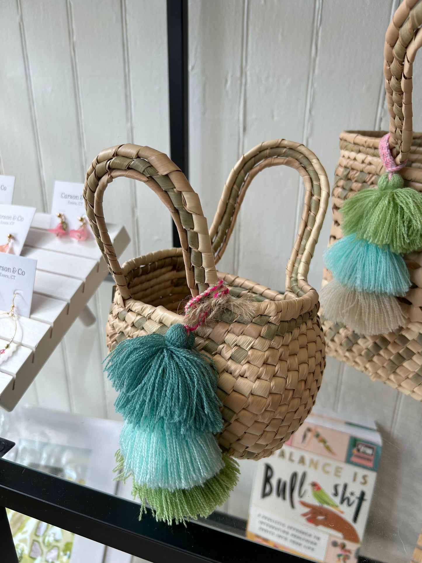 Photo of the Palm Net Yatzil Mini Tote in Sage displayed on the shelf at Grace & Haven, showcasing its handwoven palm leaf design, compact size, and artisanal craftsmanship.