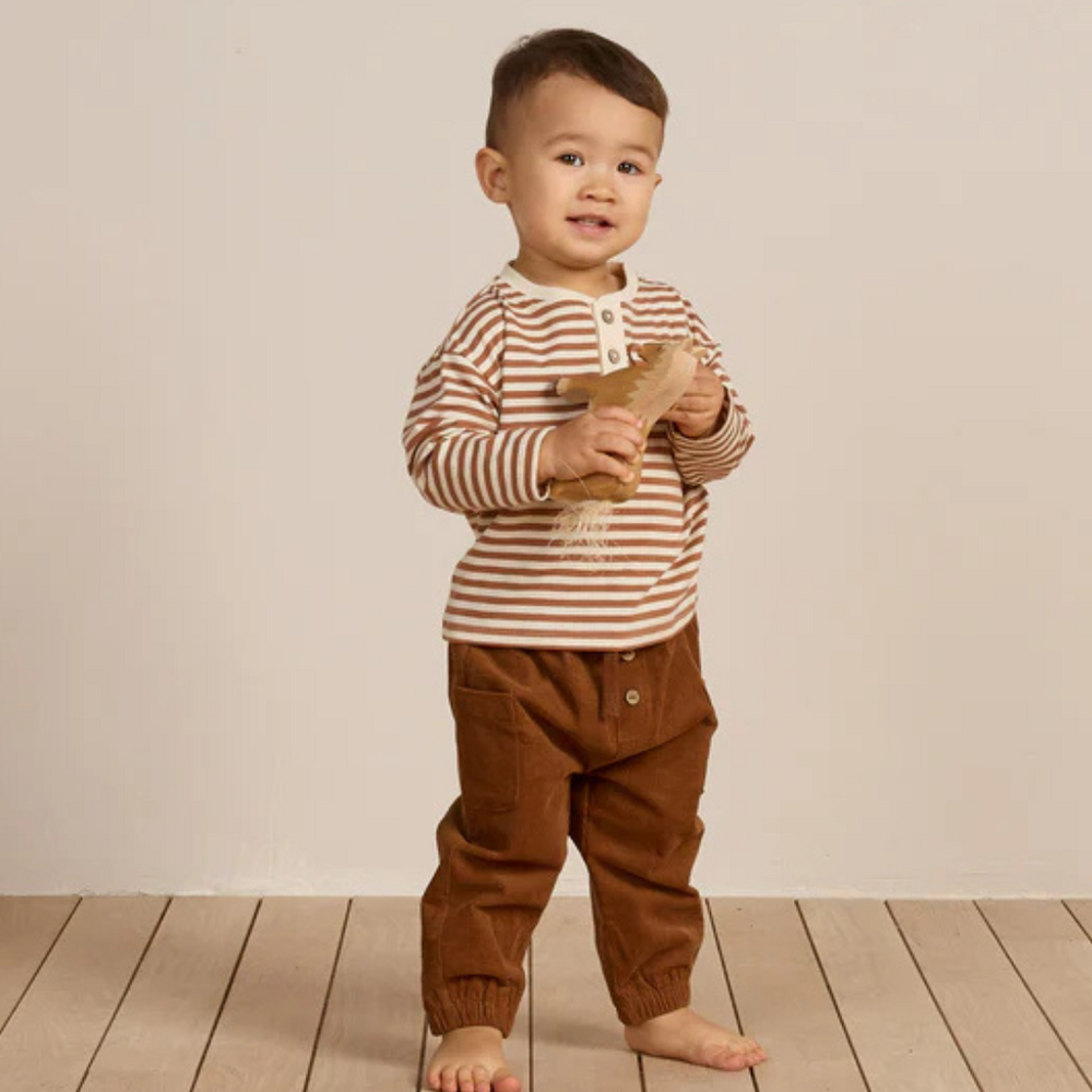 
                      
                        Toddler standing in cinnamon stripe Henley Tee, showcasing relaxed fit and comfortable stretch fabric.
                      
                    