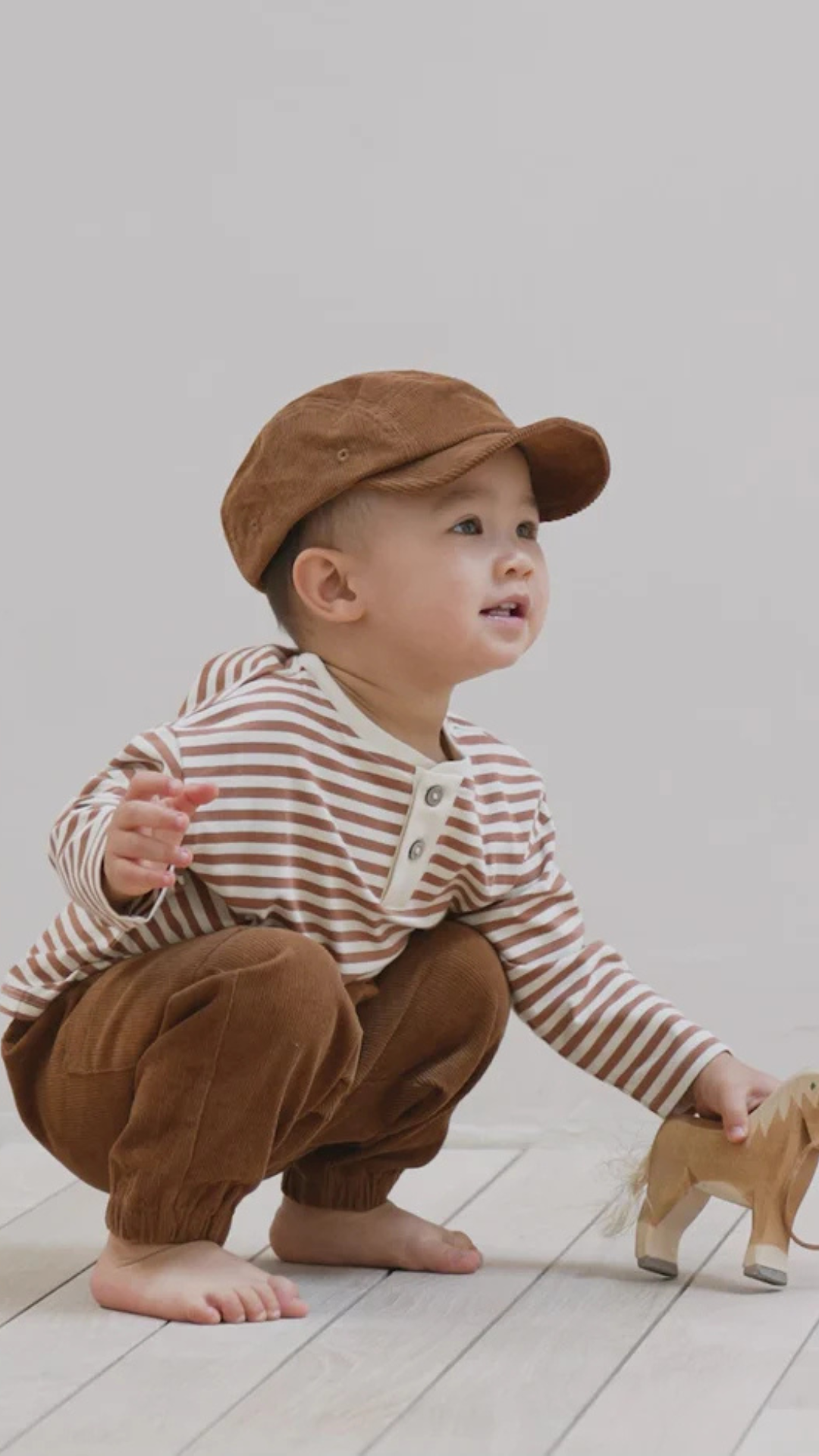 Side angle of the cinnamon Corduroy Baby Cap showing its soft, organic corduroy texture.