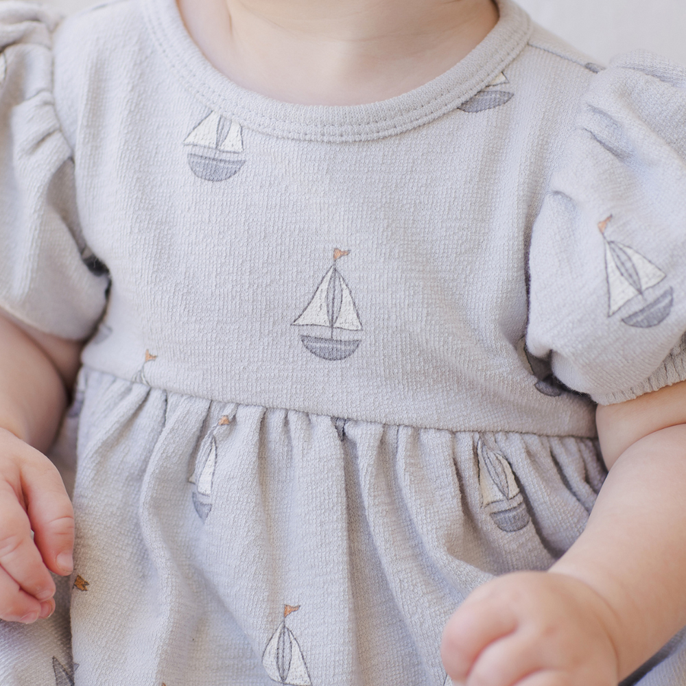 
                      
                        A detailed close-up of the Quincy Mae dress, capturing the softness of the fabric, delicate stitching, and beautiful design elements that make it a must-have for little ones.
                      
                    