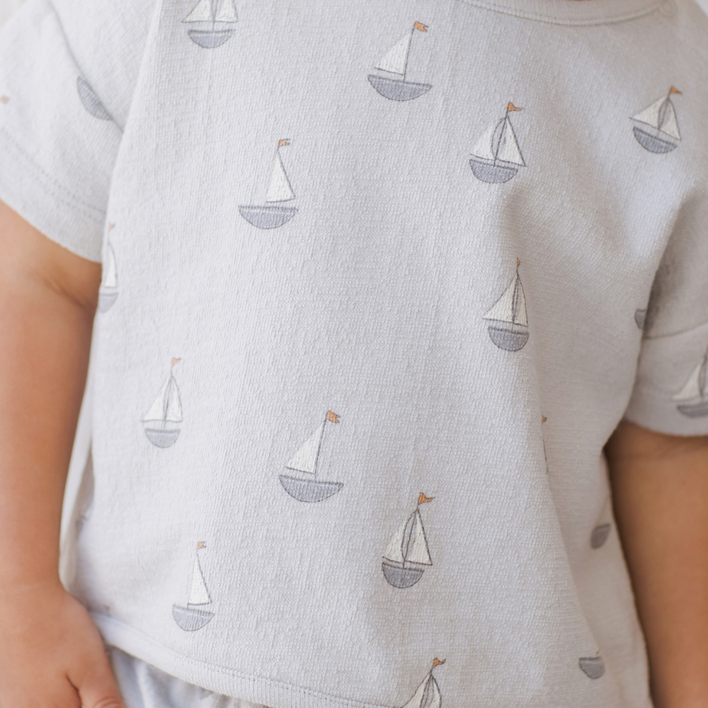 A detailed close-up of a toddler boy wearing the Spongy Play Set - Sailboats by Quincy Mae, showcasing the ultra-soft, breathable fabric and charming nautical sailboat print.