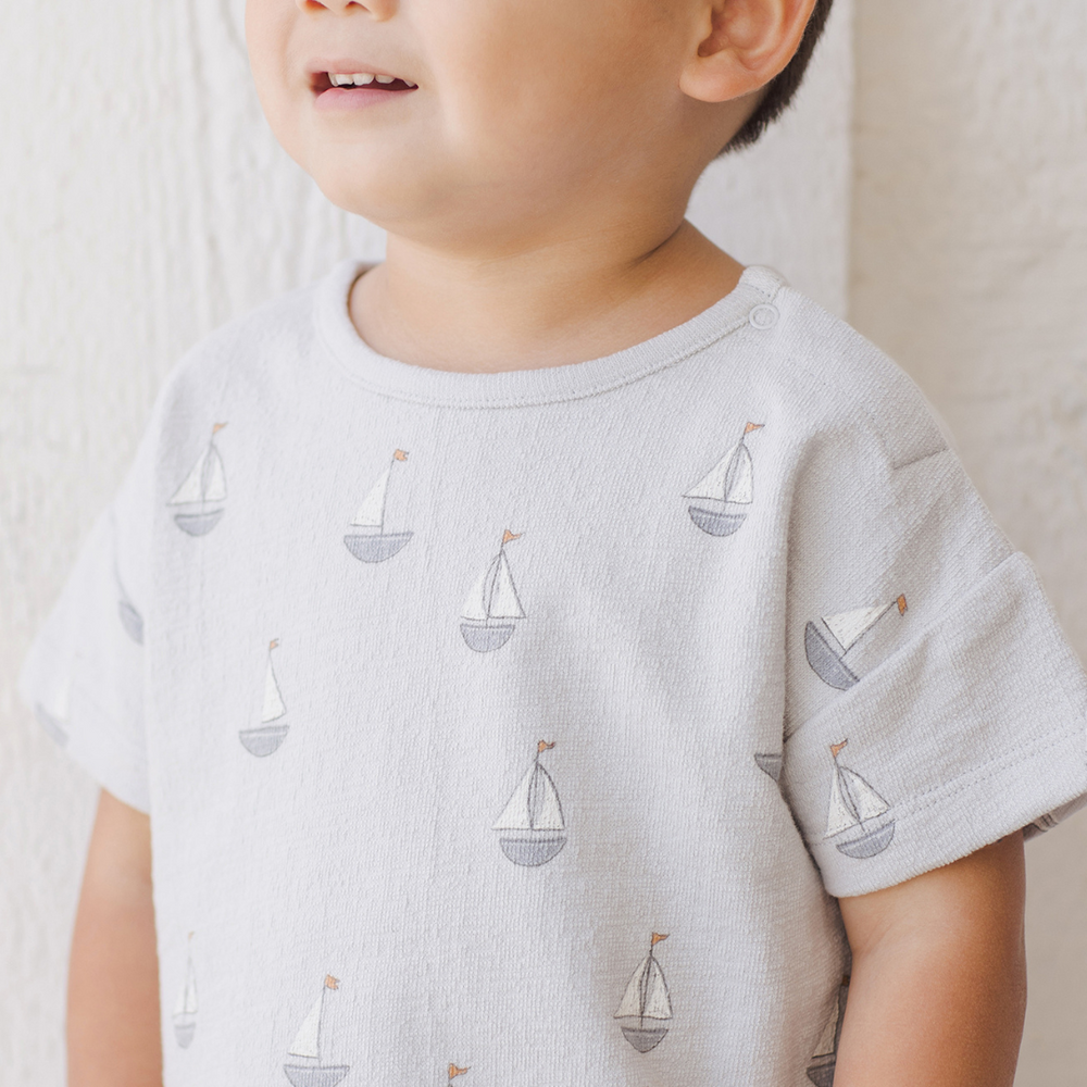 
                      
                        A close-up of the relaxed-fit top from the Spongy Play Set, highlighting the soft texture and playful sailboat design, perfect for warm-weather comfort.
                      
                    