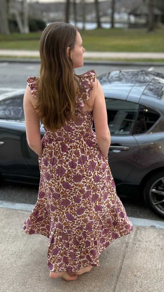 
                      
                        Back view of my sister wearing the Sasco Dress in Lilac Orsay Floral by Marea outside our shop in Essex, CT – highlighting the elegant ruffle sleeves and playful staggered hem, ideal for spring events.
                      
                    