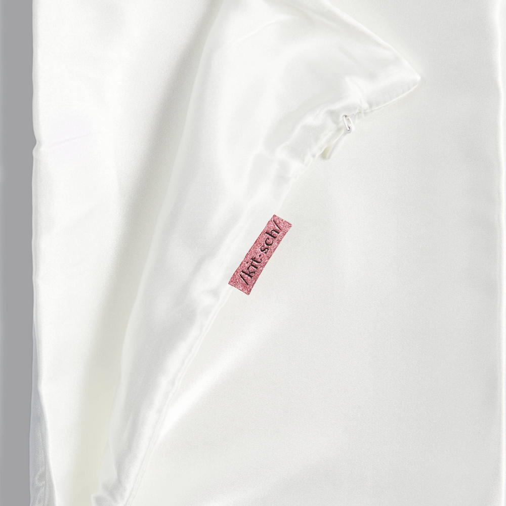 
                      
                        Close-up image of the Satin Pillowcase in Ivory by Kitsch, focusing on the sleek satin fabric texture, perfect for reducing frizz and hydrating skin.
                      
                    