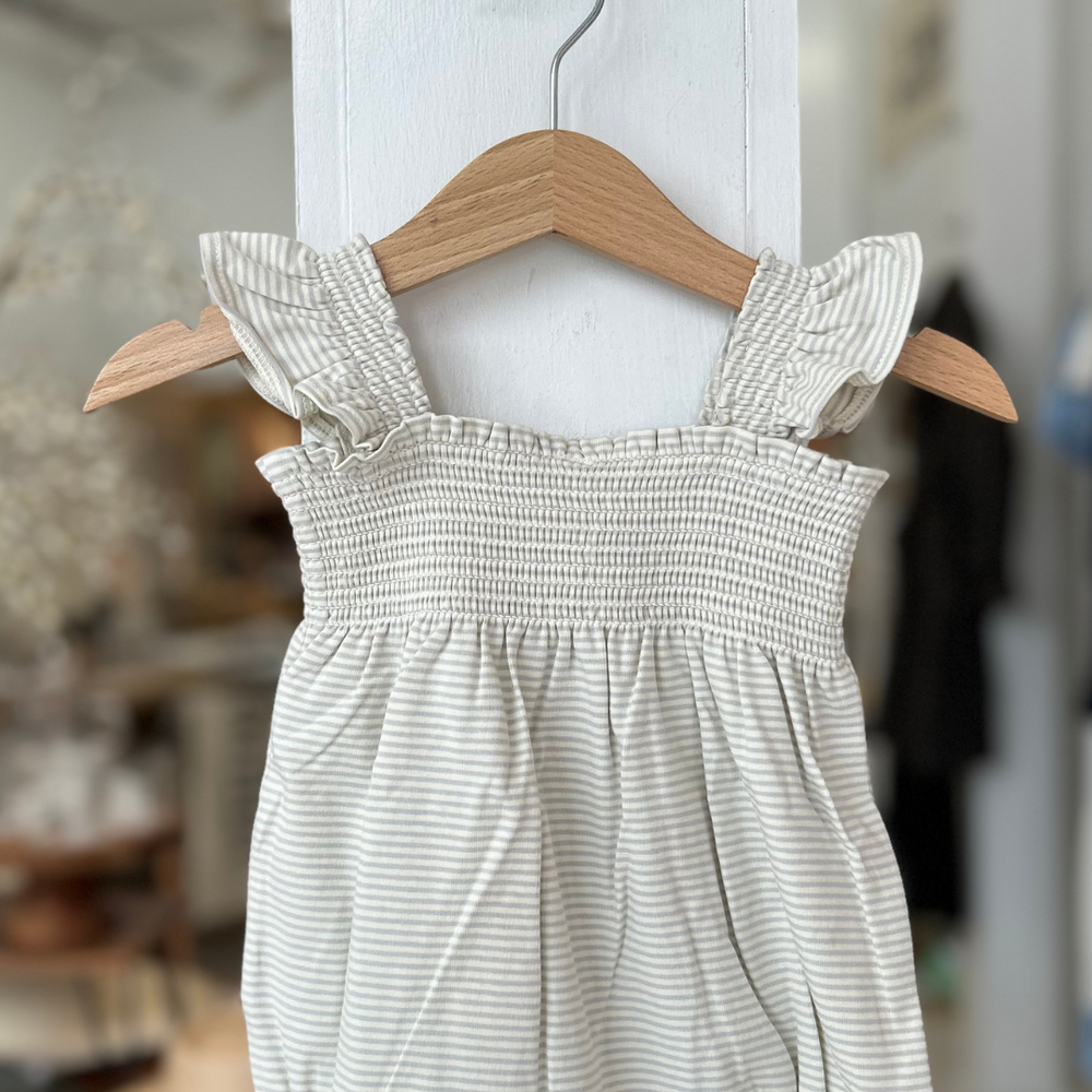 The Rylee + Cru Smocked Ruffle Sleeve Romper – Sky Stripe is a dreamy blend of comfort and charm, perfect for warm-weather adventures. 