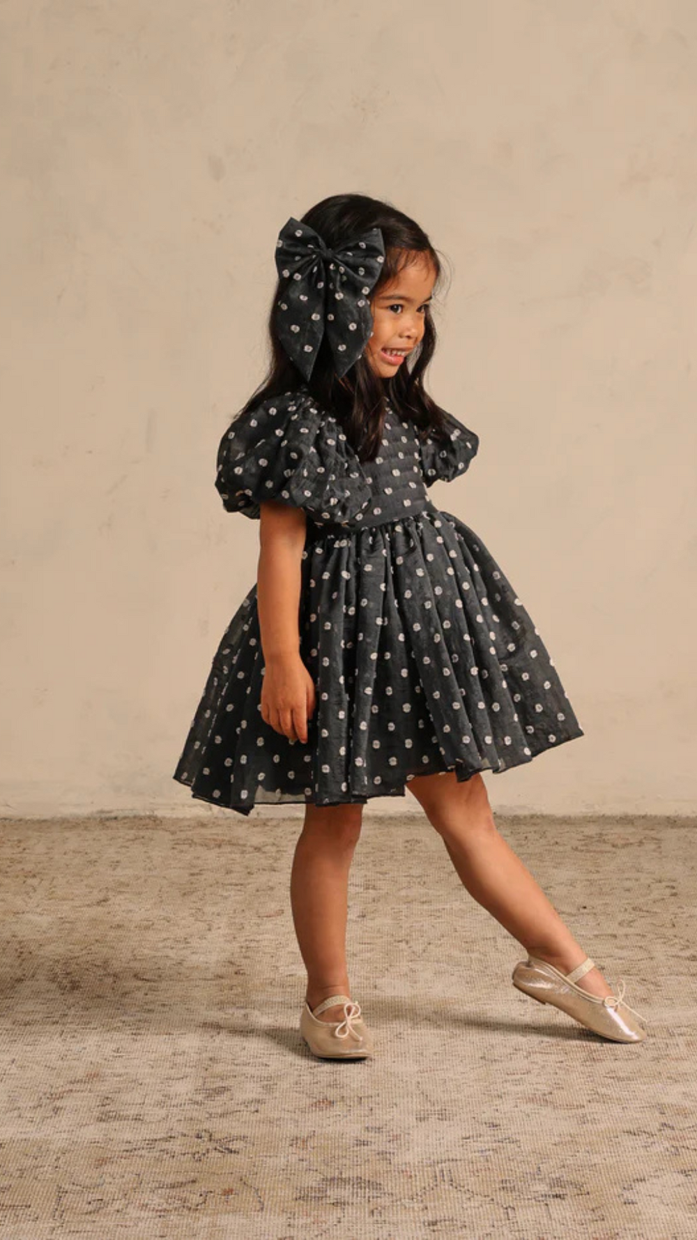 Playful model wearing the Sophia Dress in a studio, capturing the dress’s whimsical charm and comfortable fit as she twirls with joy.