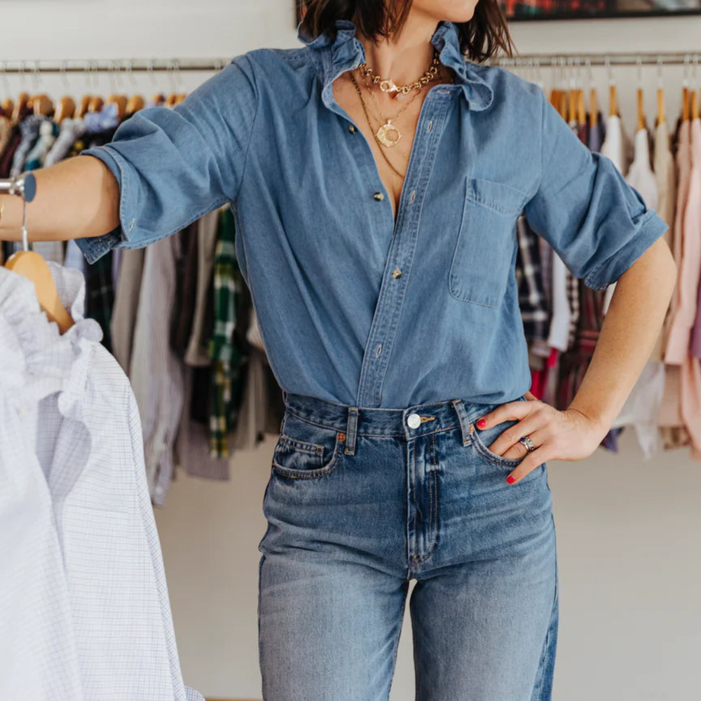 
                      
                        Denim ruffle collar blouse styled with sleeves rolled up and tucked in for versatile look
                      
                    