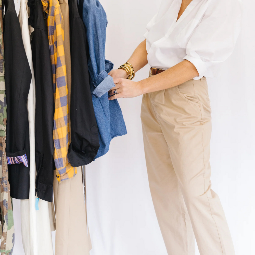 
                      
                        Kate showcasing her creative vision in the Southern Lover in White, surrounded by her reimagined designs on a rack, embodying the essence of sustainable fashion.
                      
                    