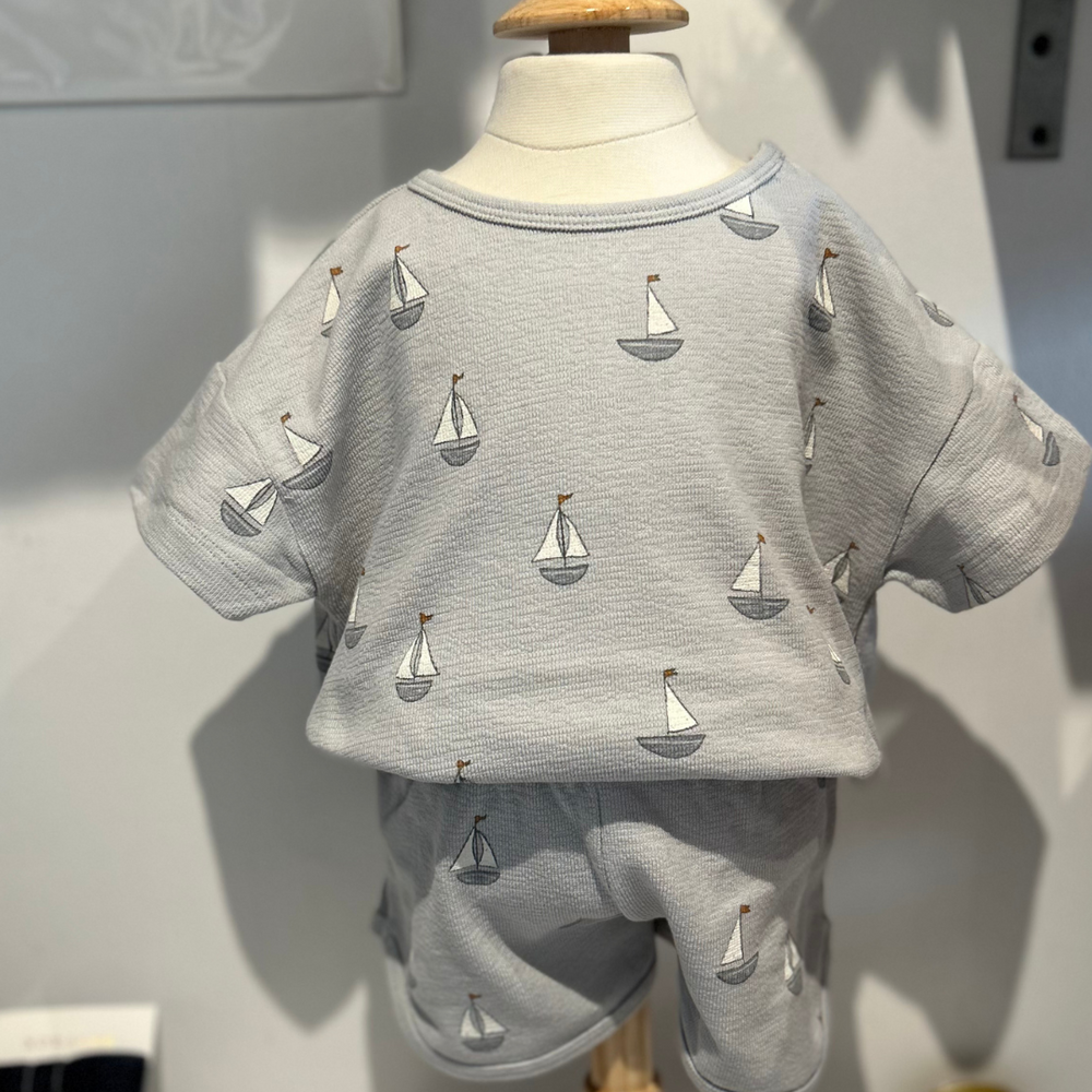 
                      
                         Designed for all-day comfort, this adorable two-piece set features a charming sailboat print on soft, breathable fabric. 
                      
                    