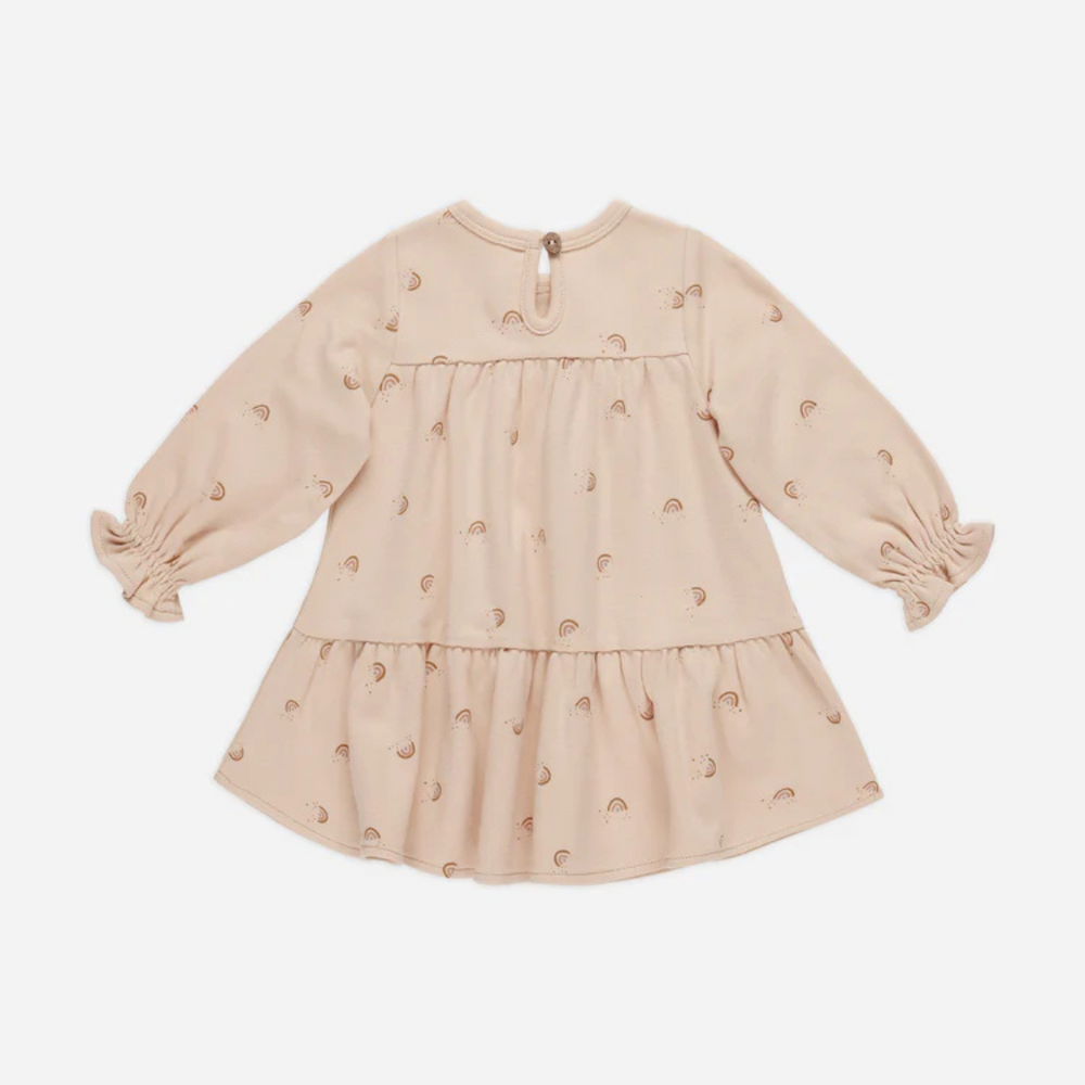 
                      
                        Back view of Quincy Mae Tiered Jersey Dress in Rainbows, highlighting the comfortable tiered silhouette and long sleeves on soft shell-colored fabric for little girls’ wardrobes.
                      
                    