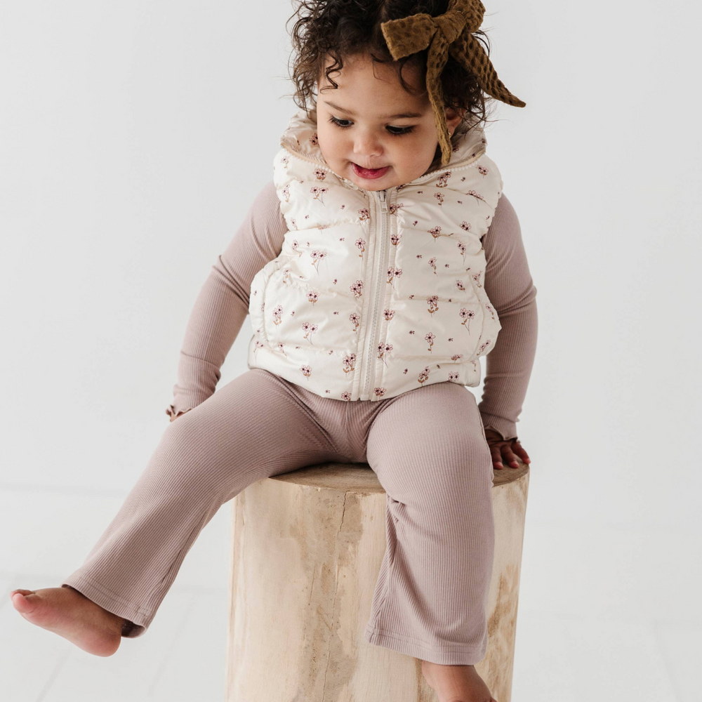 Toddler sitting in ribbed bamboo flare pants, showcasing soft, stretchy fabric. Comfortable and stylish for fall, paired with a Lettuce Hem Tee