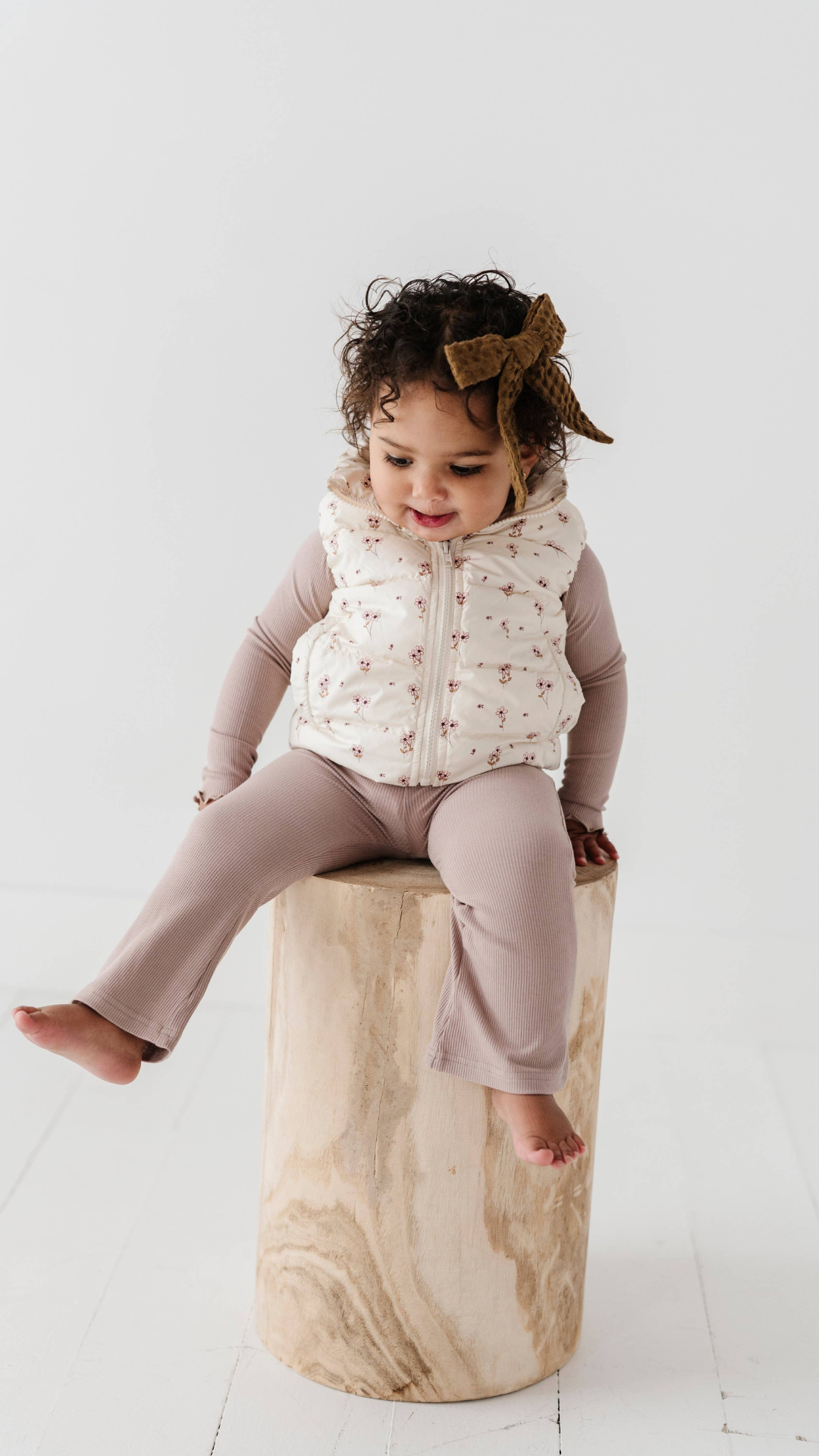 Toddler sitting in ribbed bamboo flare pants, showcasing soft, stretchy fabric. Comfortable and stylish for fall, paired with a Lettuce Hem Tee