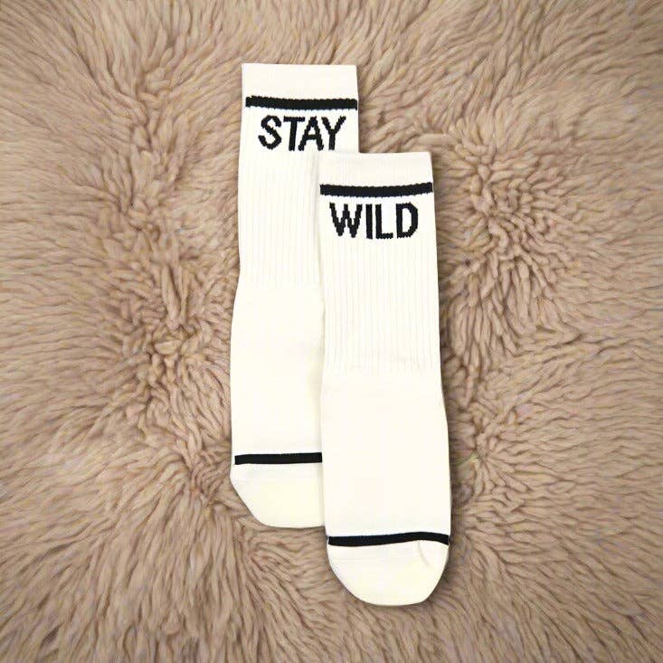 Flat lay of Atticus Poetry Stay Wild crew socks in ivory and black showing full length and silhouette