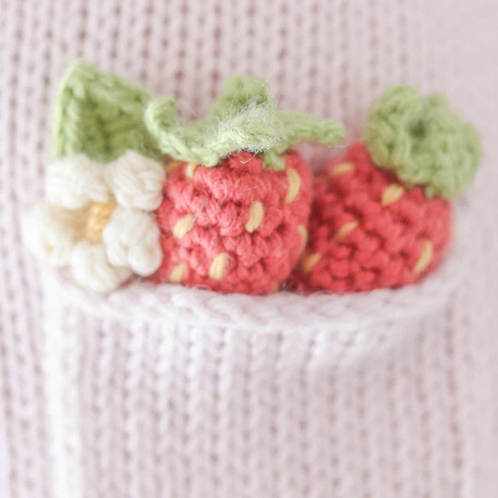 
                      
                        Close-up of Ava the Cow’s lavender dress pocket featuring hand-embroidered strawberries and a delicate flower, highlighting artisan craftsmanship
                      
                    