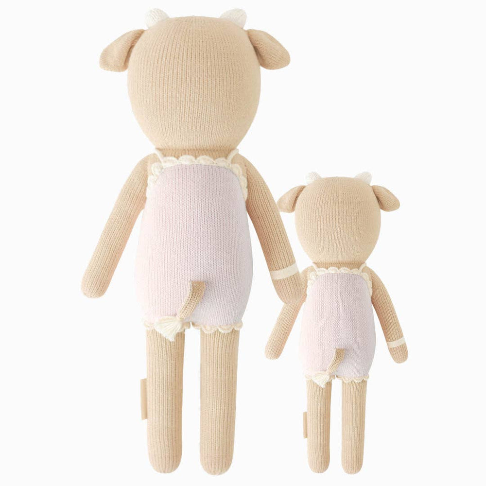 Back flatlay of Ava the Cow hand-knit dolls in lavender showing both little and regular sizes with tail and flower pocket details