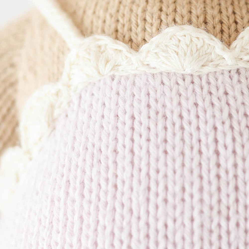 
                      
                        Detail of Ava the Cow's scalloped lavender dress hem, showing intricate hand-knit design and soft cotton texture
                      
                    