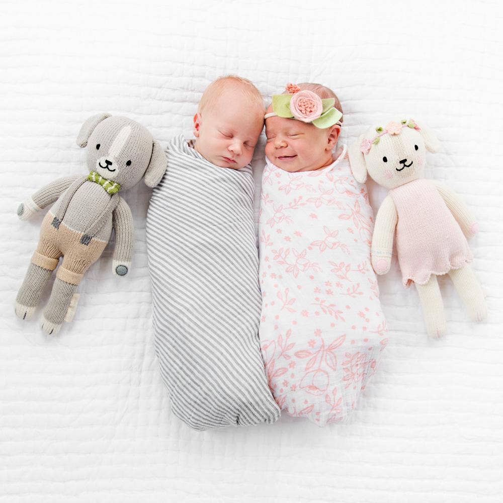 
                      
                        Two babies sitting with Noah the Dog and another cuddle+kind puppy doll, soft, fair trade companions for little ones.
                      
                    