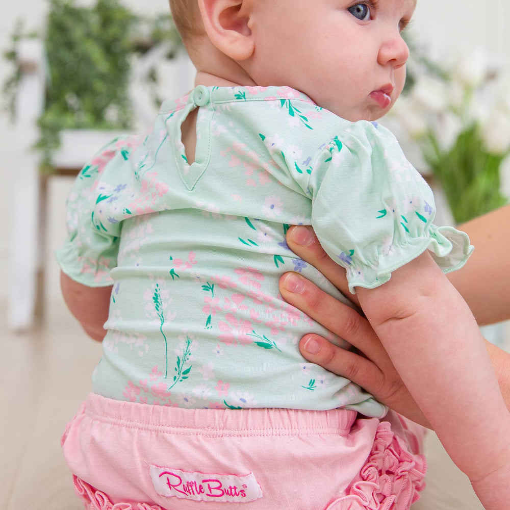 
                      
                        Back view of baby girl wearing mint meadow floral bodysuit with puff sleeves and cozy fit
                      
                    
