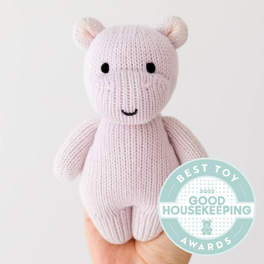 
                      
                        Cuddle + Kind lavender baby hippo plush shown in adult hand to illustrate 7” size, perfect for newborns
                      
                    