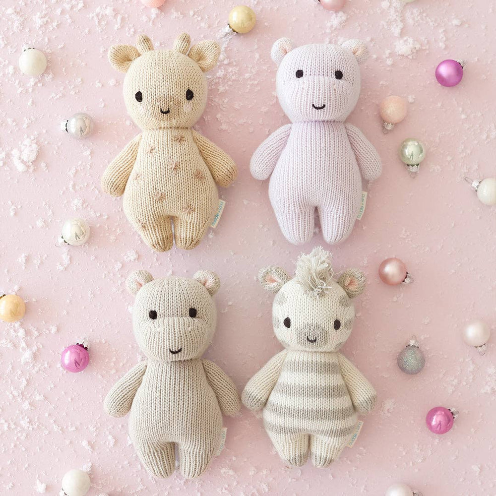
                      
                        Lavender baby hippo pictured with three other Cuddle + Kind animals, highlighting collectible and giftable doll collection
                      
                    