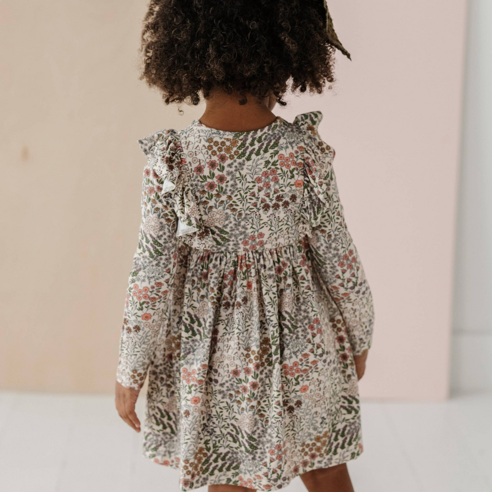 
                      
                        Back view of toddler in Winter Floral ruffle dress, showcasing the beautiful print and comfortable fit, designed for quality and durability.
                      
                    