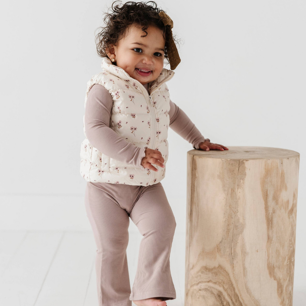 Full view of little girl in Ditsy Floral Puffer Vest, showing off the floral pattern and comfortable fit for outdoor adventures and playdates.