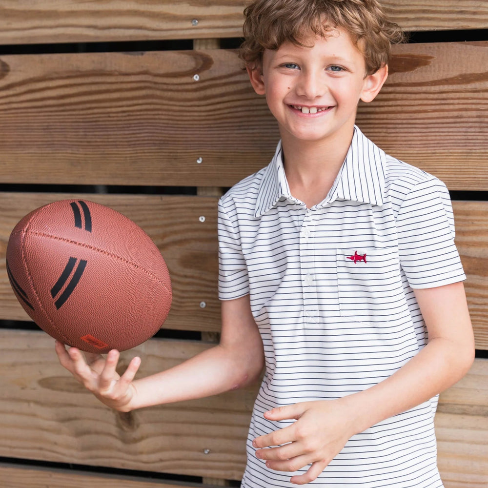 Boy in Boys Marco Performance Polo and performance shorts tossing a football, highlighting versatile, active-friendly, and stylish outfit for kids.
