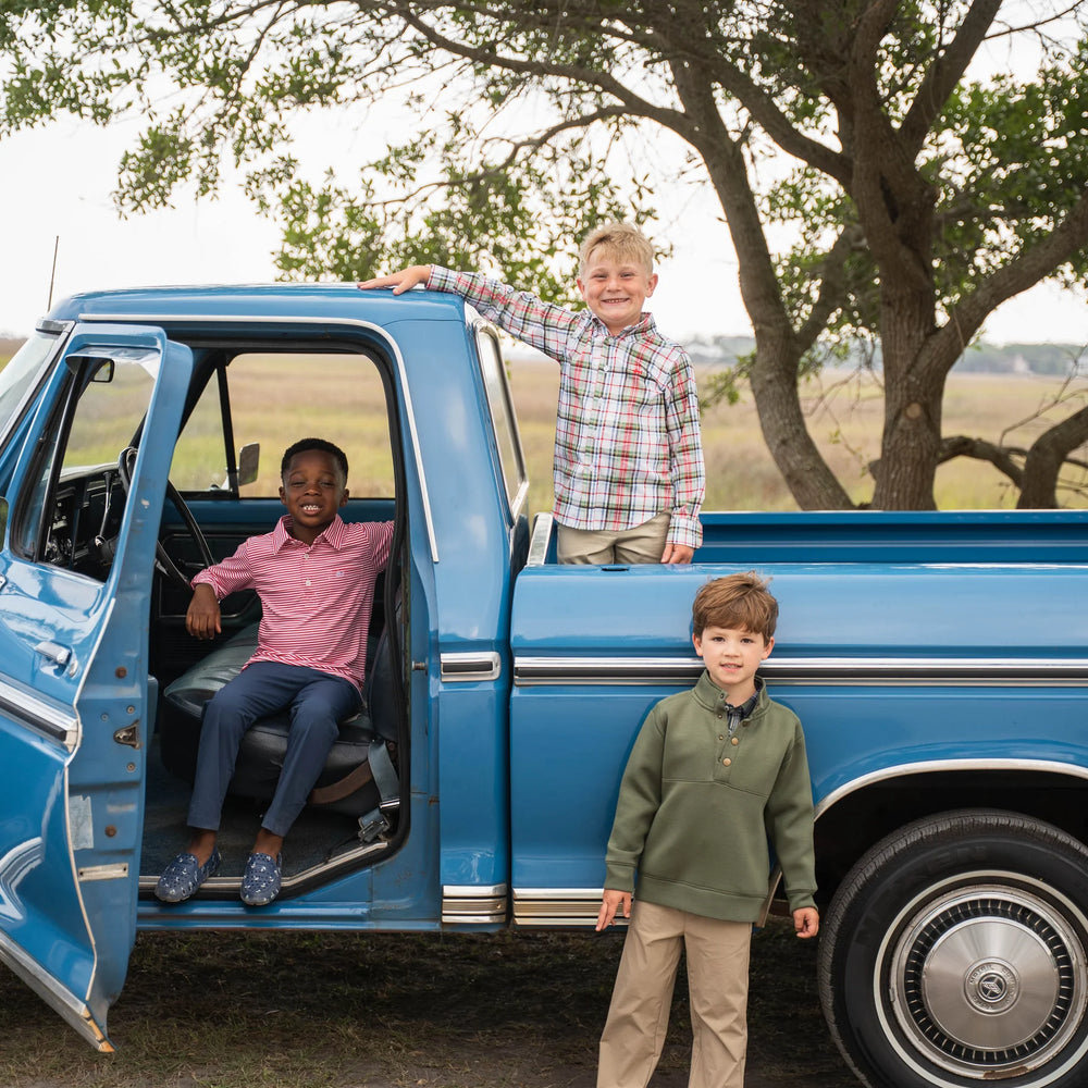 
                      
                        Boy in green Pierce Performance Pullover with performance pants standing in front of truck beside two boys in Oxford and other Saltwater Boys fall favorites, highlighting timeless fall outfit styles.
                      
                    