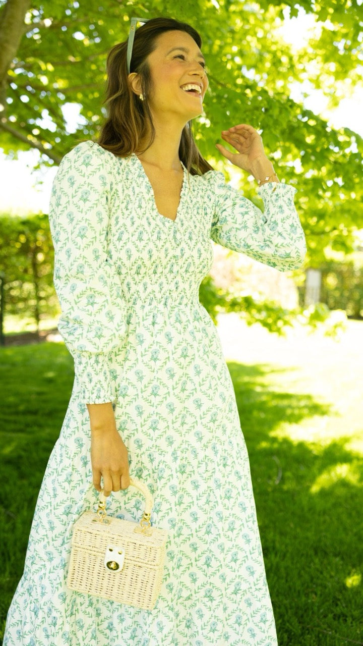 Model wearing the Bridgette Dress in trellis print standing under a tree at an outdoor wedding, styled for a summer celebration.
