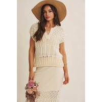 Open Knit Pointelle Crochet Sweater in cream with intricate lace-like patterns, worn by a woman holding a pink flower