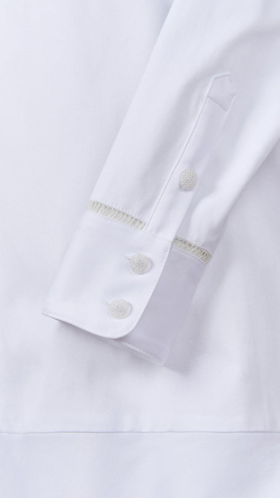 
                      
                        Detailed view of the Callaway Dress cuff showing ladder lace and delicate glass button accents for an elevated finish.
                      
                    