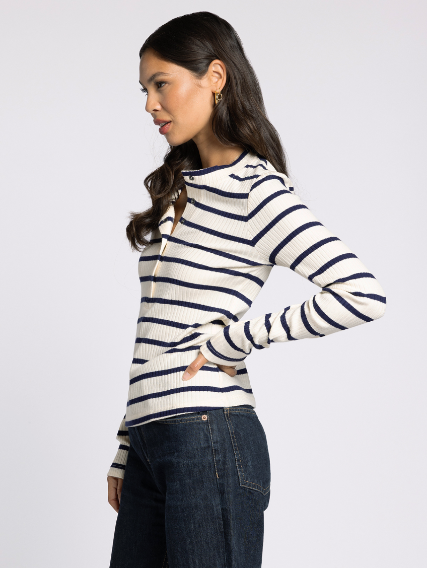 Side profile of the Carina Ribbed Henley in ivory with navy trim, showing slim fit and long sleeves.