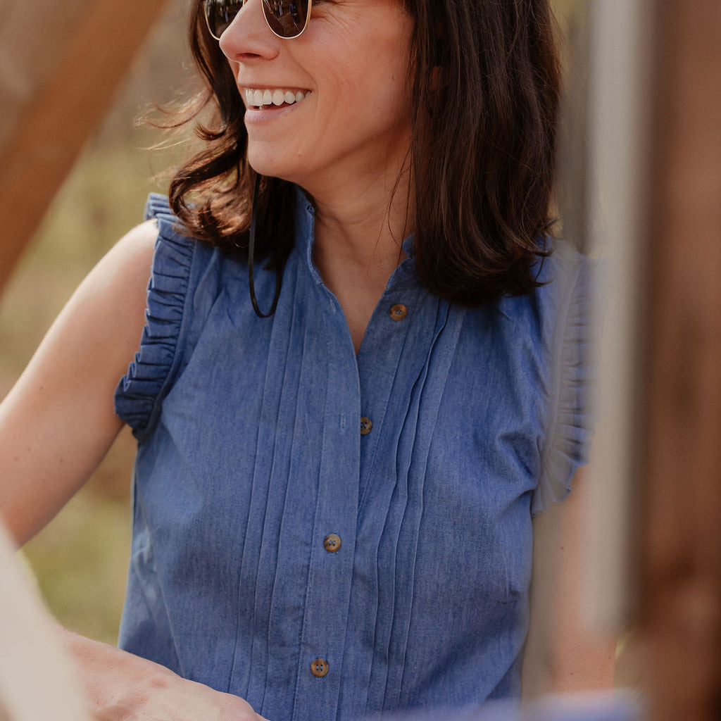 Lifestyle shot of model wearing blouse outdoors, showing airy fit