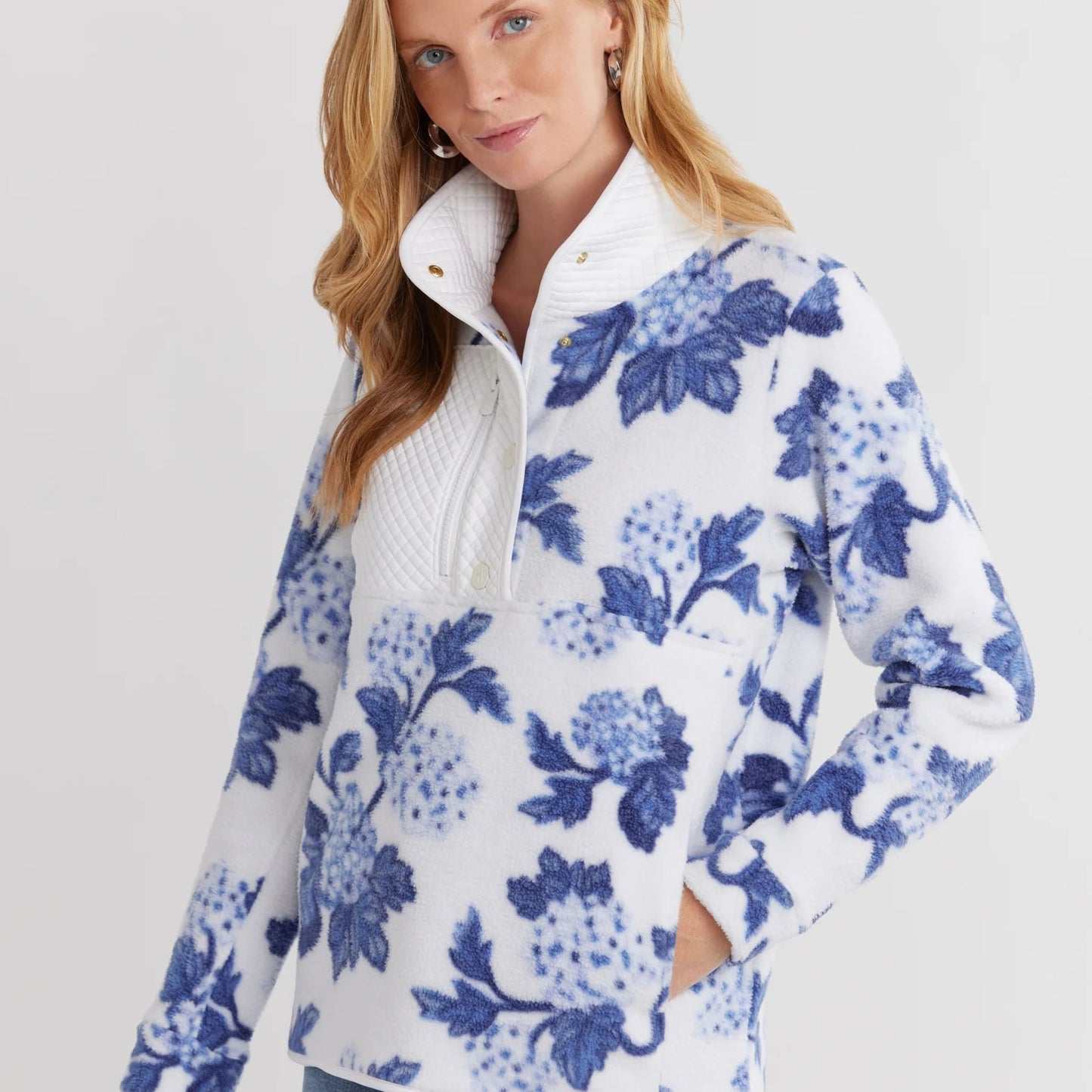 Model wearing Cherry Lawn Sherpa Fleece Pullover in hydrangea floral print, relaxed fit and chest zip pocket visible